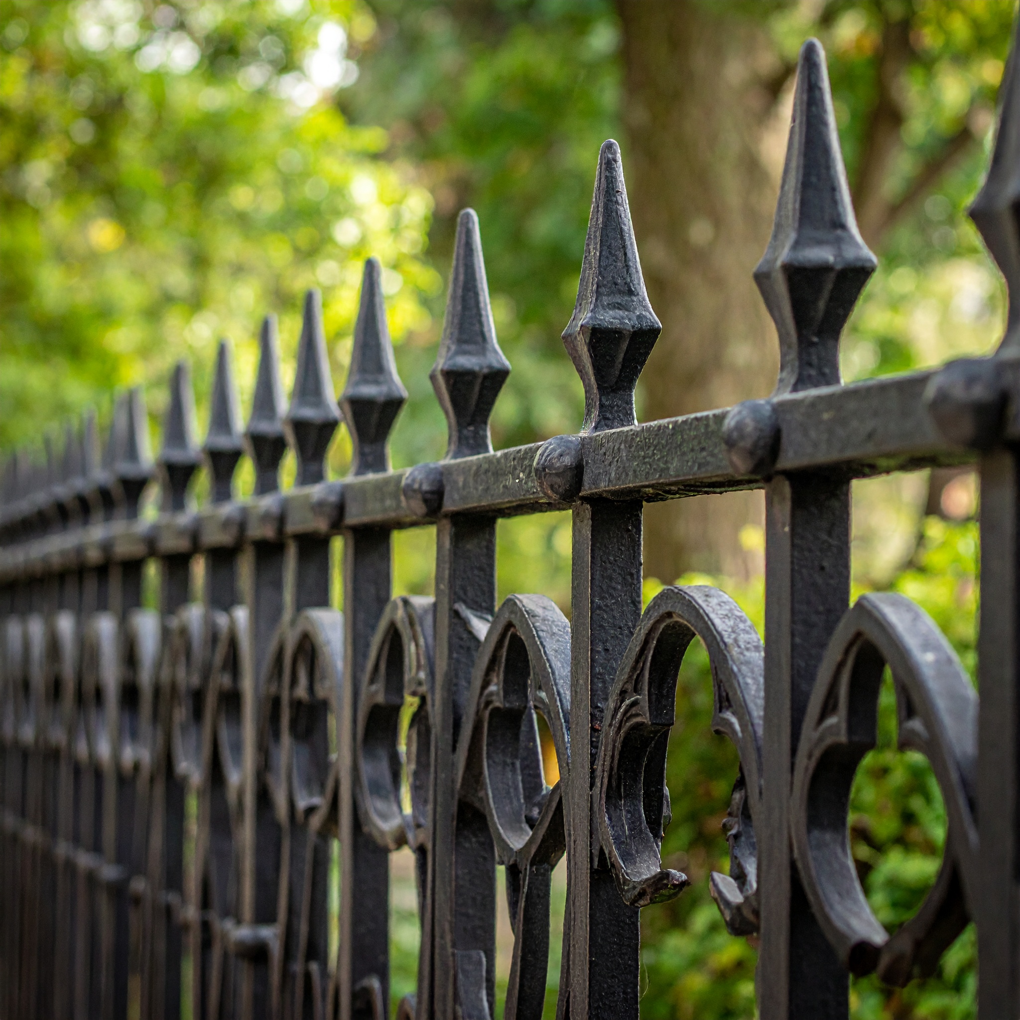 A traditional Gothic-style wrought iron fence with pointed arch patterns at the botto 933581 - San Antonio Deck and Fence Works Black wrought iron fence with finials-deck builder-San Antonio, Texas