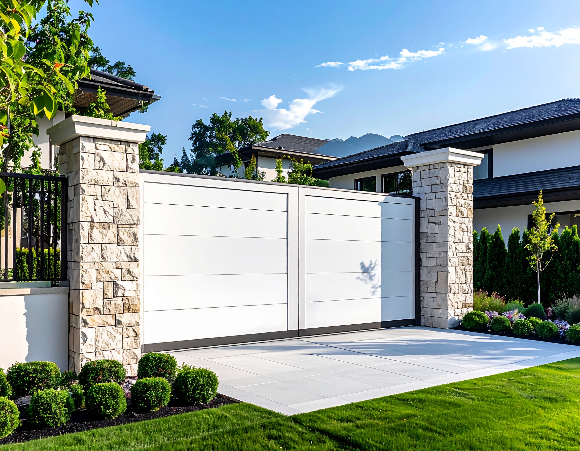 Clean white automatic estate gate with tall stone columns minimalist luxury home in 124448 - San Antonio Deck and Fence Works White vinyl gate with stone pillars-deck builder-San Antonio, Texas