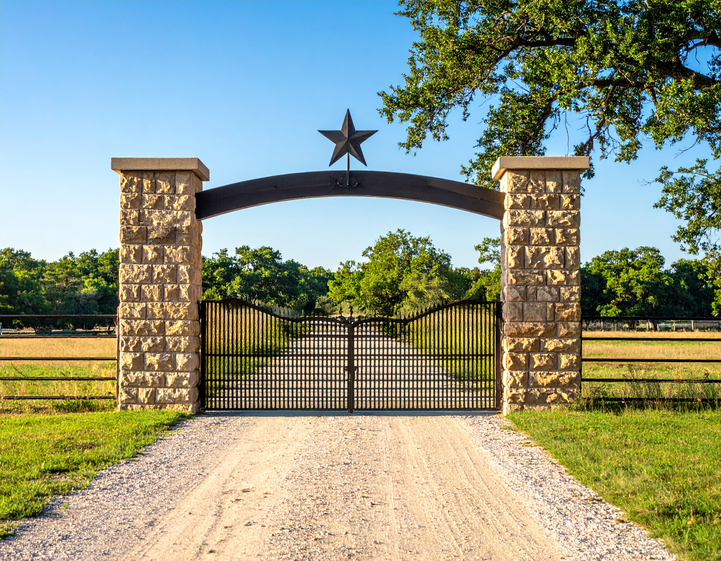 Stone Pillar Ranch Gate with Star Design_A wide ranch entrance with stone columns and 347641 - San Antonio Deck and Fence Works Stone pillars with metal star gate.-deck builder-San Antonio, Texas
