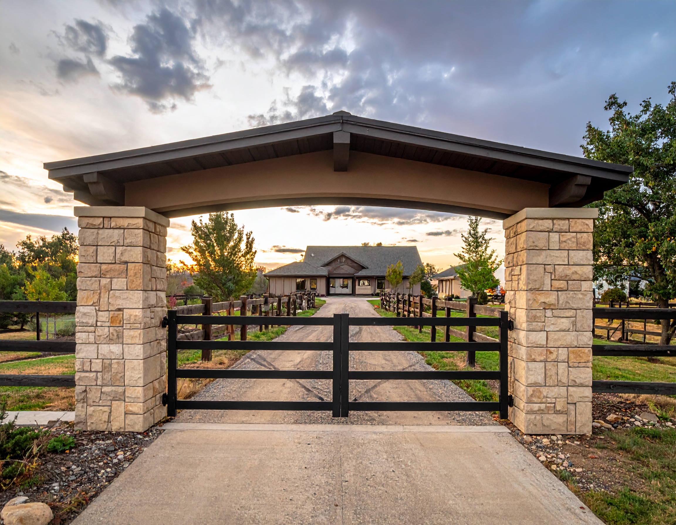 Stone and Metal Ranch Gate with Horizontal Rails_Estate entrance with cream-colored s 512641 - San Antonio Deck and Fence Works Stone pillars with black metal gate-deck builder-San Antonio, Texas