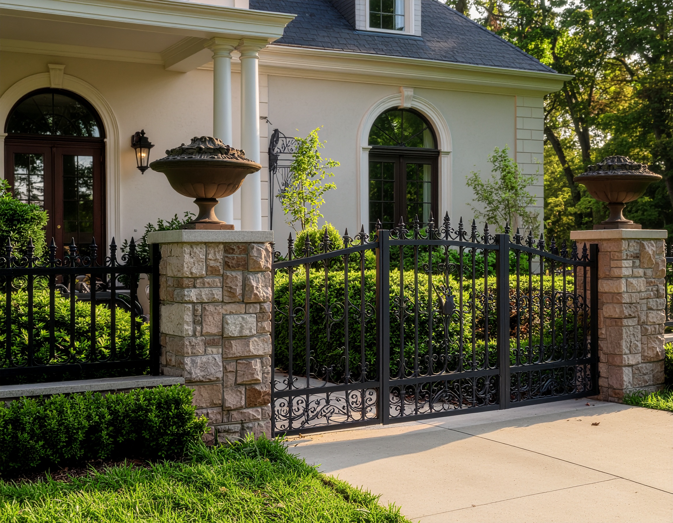 Black wrought iron gate with stone pillars.-deck builder-San Antonio, Texas